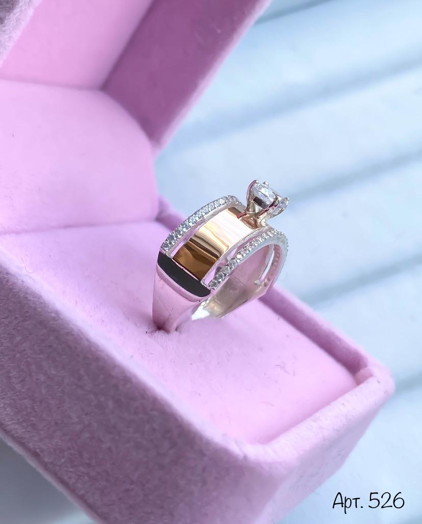 Gold and silver ring with diamonds on a pink cushion